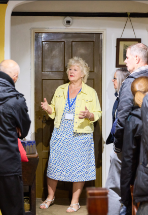 A tour guide speaking to a group of people in front of an entrance