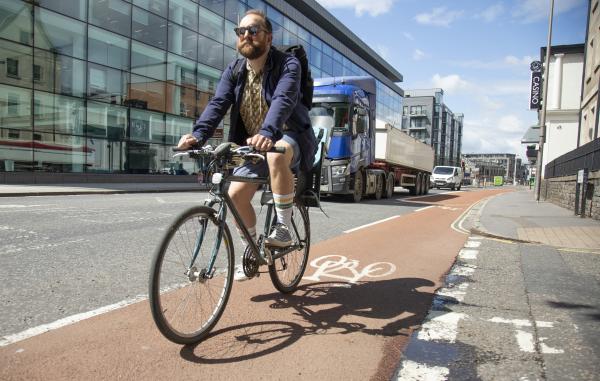 Man with a beard cycling in shorts in Bristol
