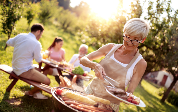 family using an outdoor barbeque in the garden