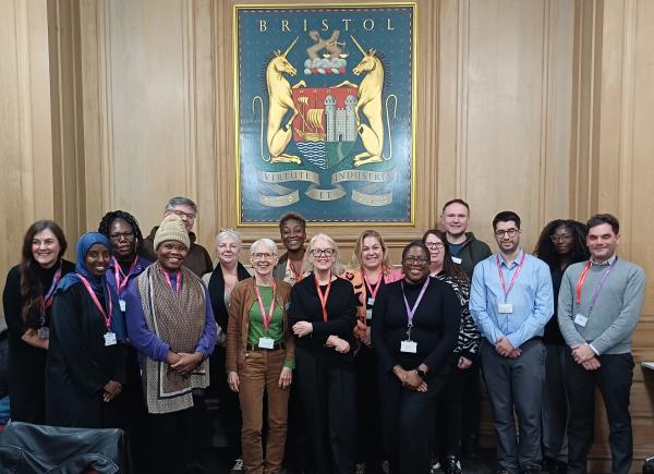 The Resident and Community Panel are stood with housing staff underneath a Bristol City Council plaque