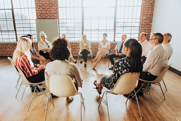 A group of people sat in a circle having a meeting