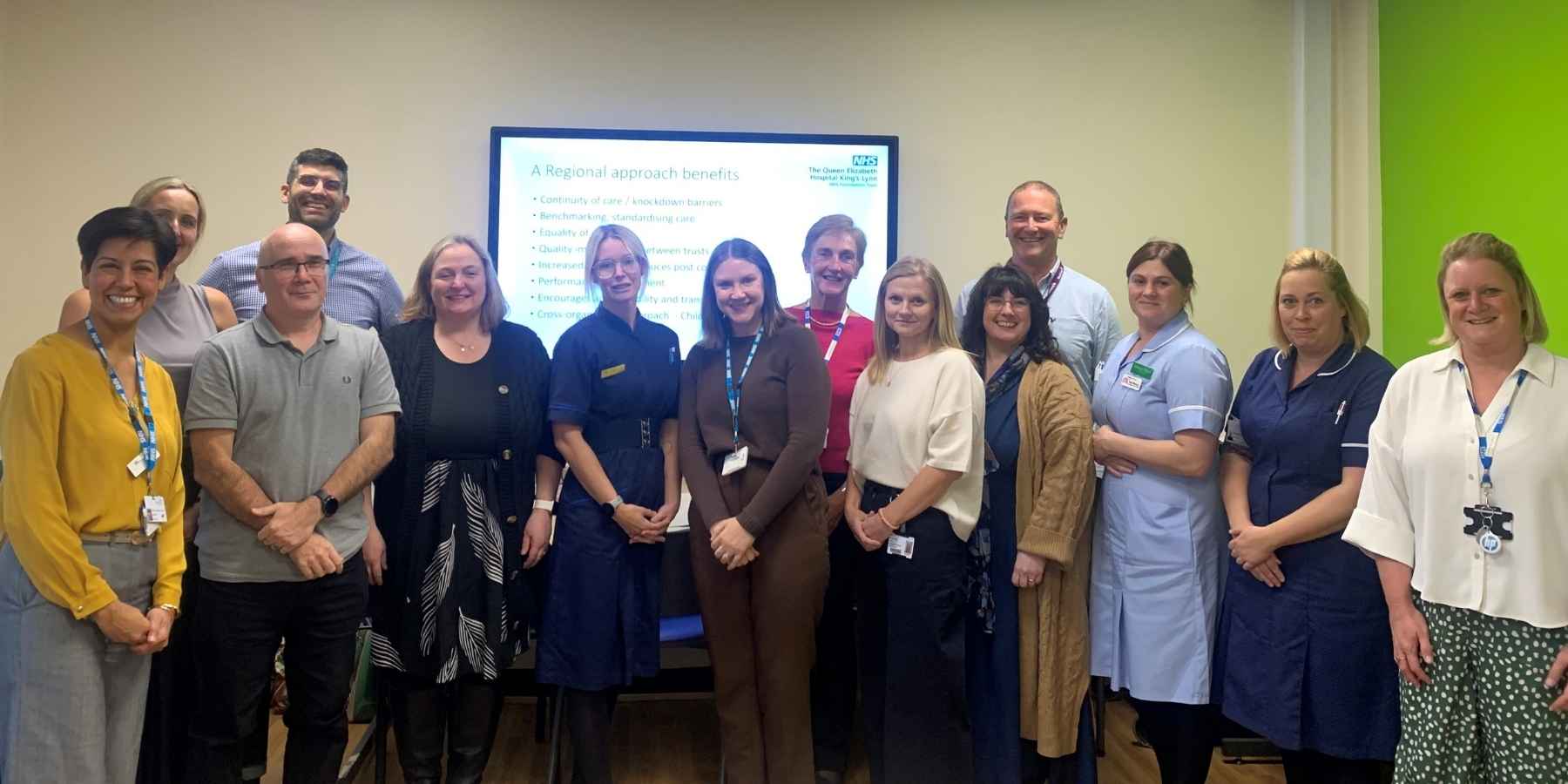 A group of men and women smiling at the camera. Some are in nurses uniforms.